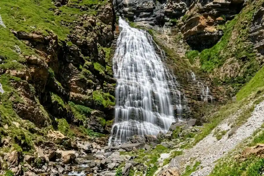 Cartel de madera en la naturaleza con preguntas frecuentes sobre la ruta a la Cascada de la Cola de Caballo