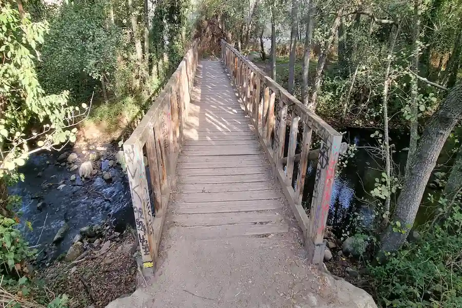 Puente de madera cruzando el río en La Pedriza