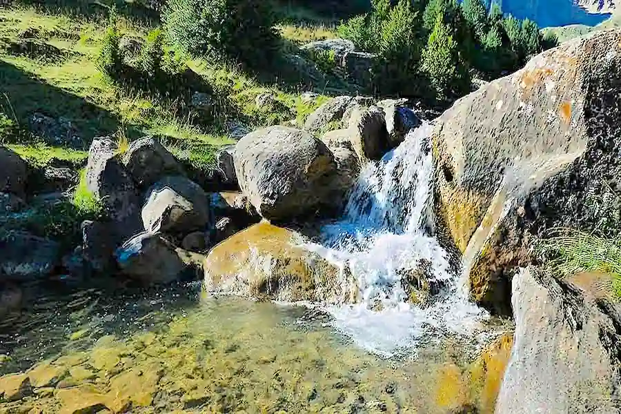 Sendero que discurre junto al margen derecho del arroyo de montaña