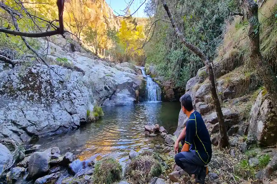 Poza de agua cristalina formada bajo la cascada